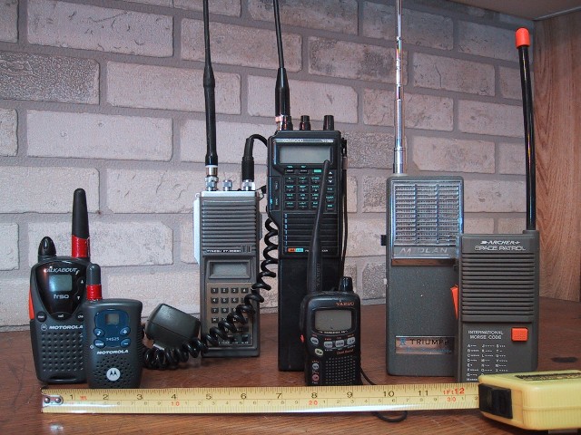 Several handheld walkie-talkies of different makes standing side by side, for storm prep in Daphne, AL